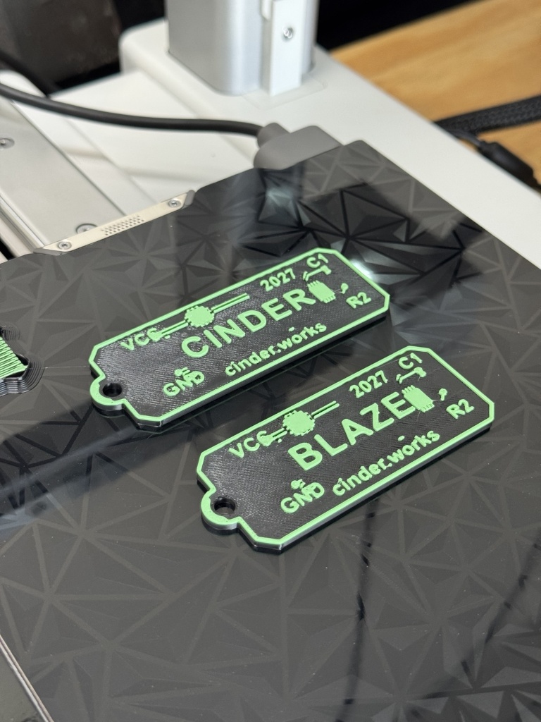 Fresh off the printer — CINDER and BLAZE keychains on Bambu A1 Mini bed