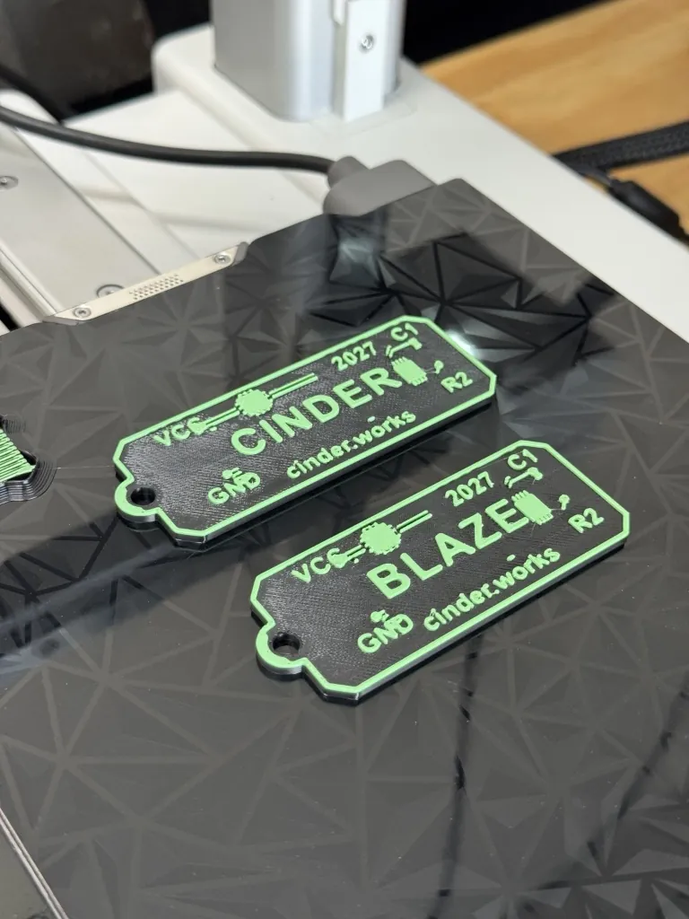 Fresh off the printer — CINDER and BLAZE keychains on Bambu A1 Mini bed